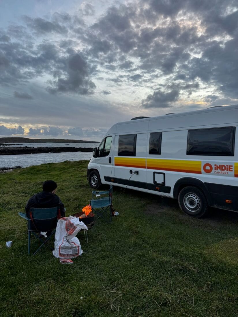 van travel around ireland having a fire by the ocean